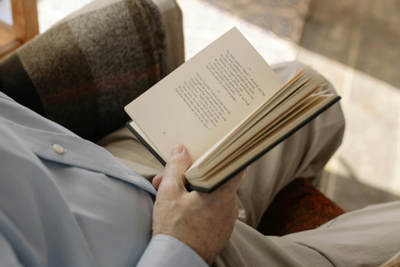 a man sitting down and reading a book