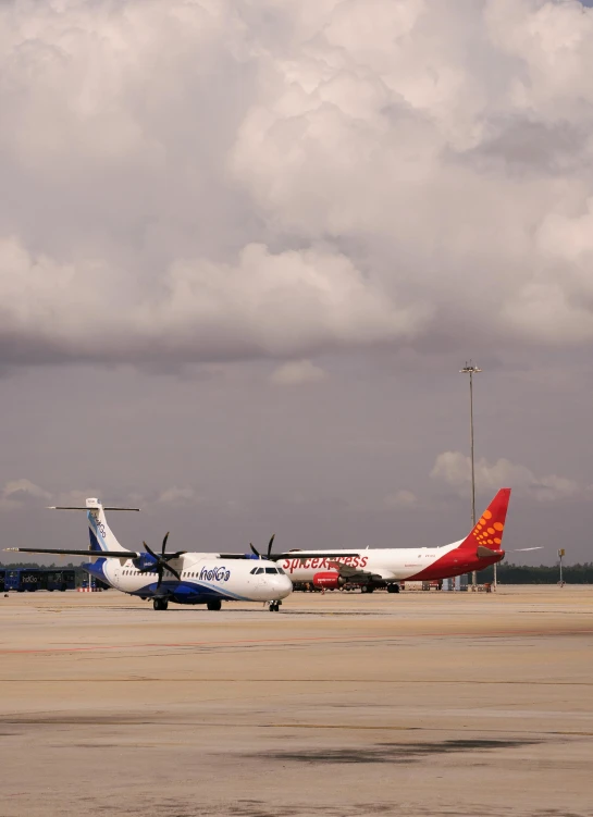 an airplane sits on the tarmac as another plane and another passenger take off