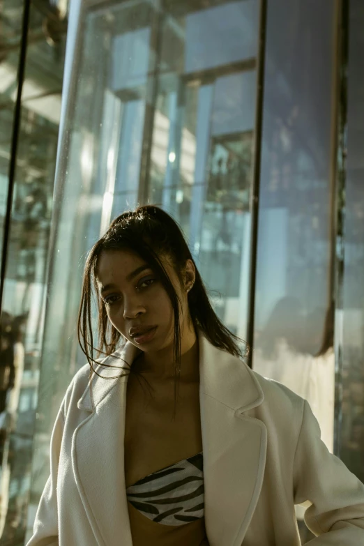 a woman sitting in front of a glass structure