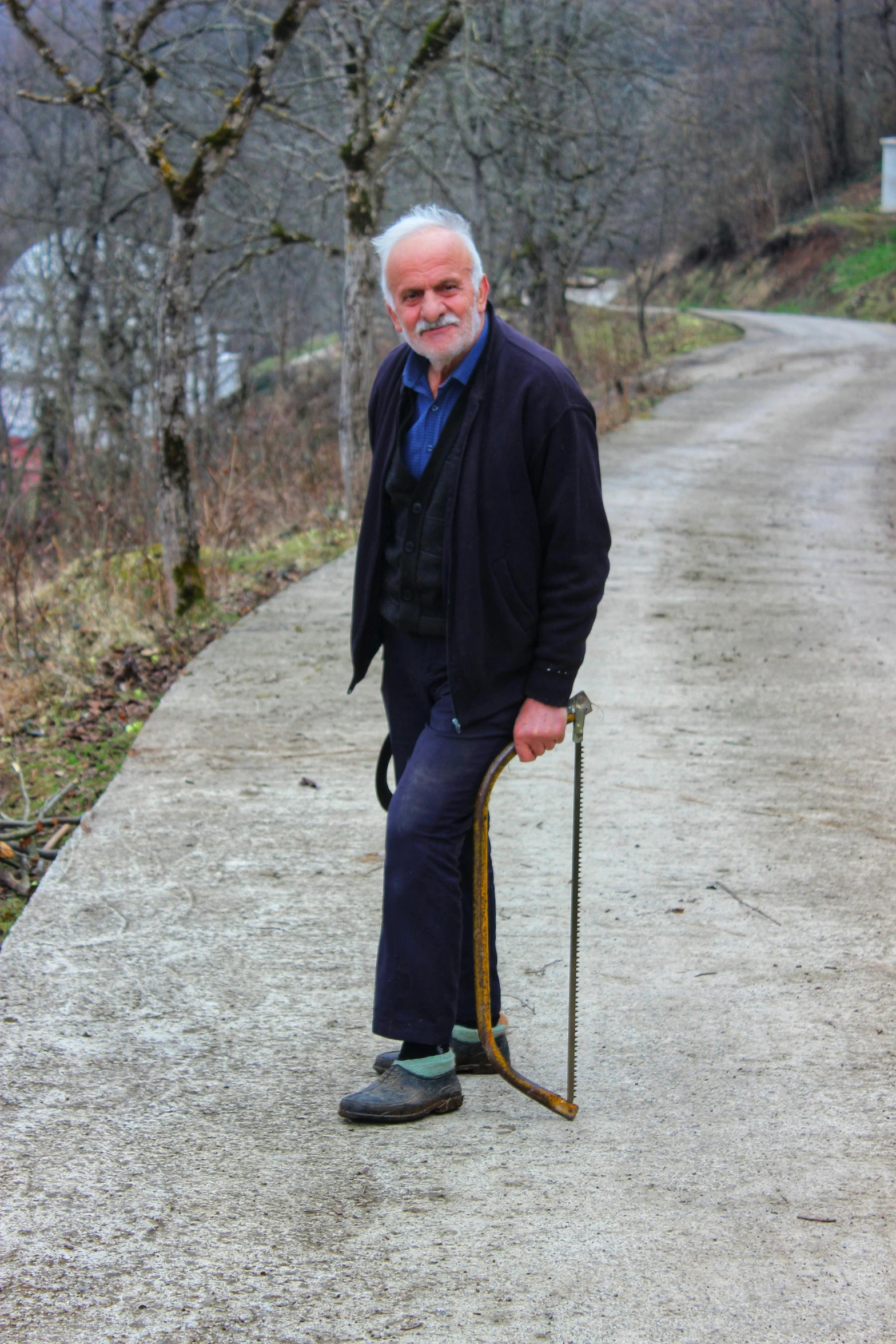 a man holding an odd looking stick on a road