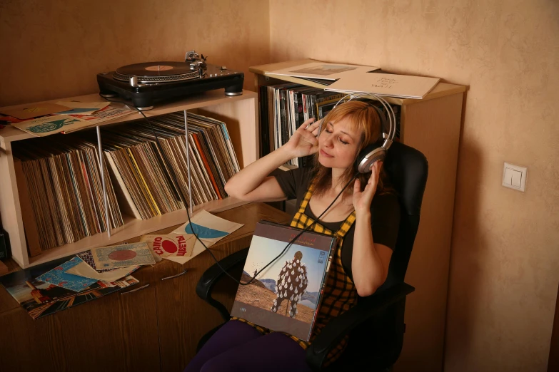 a woman sitting at her home office in front of record collection