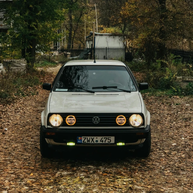 a white car is parked near some trees