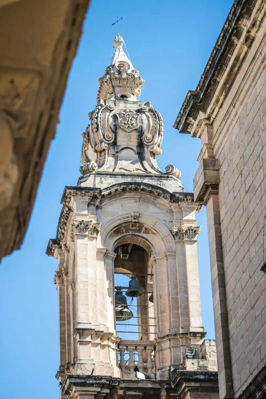 this bell tower features a large steeple and ornate carvings