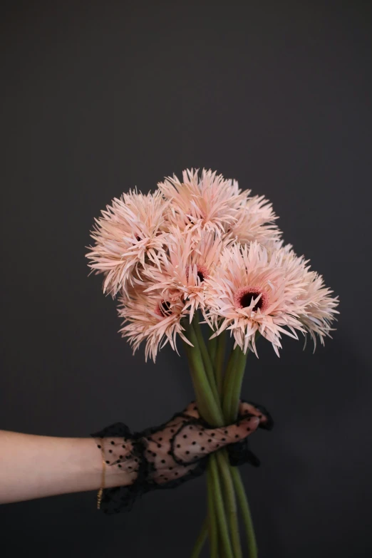 a woman's hand with a black gloves and flowers