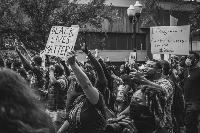 many people are gathered together holding signs that say black lives matter