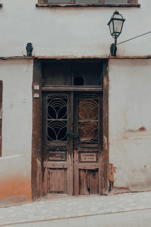 an old building with two doors and a street lamp