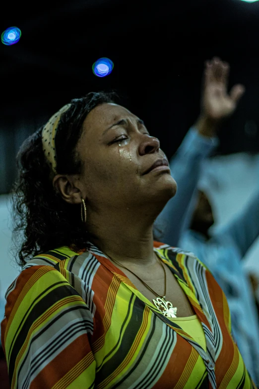 a woman is standing up to worship