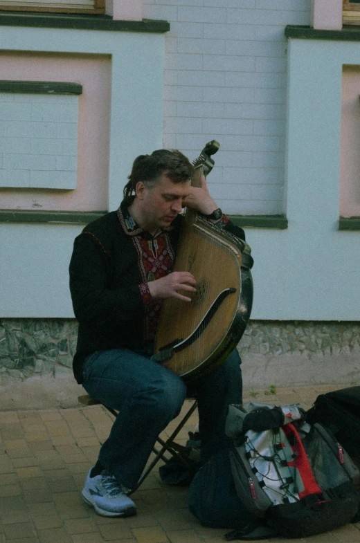 a man is holding a large harp while kneeling down