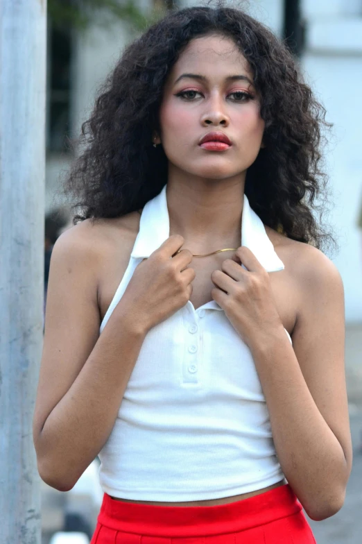 a woman that is posing on a sidewalk