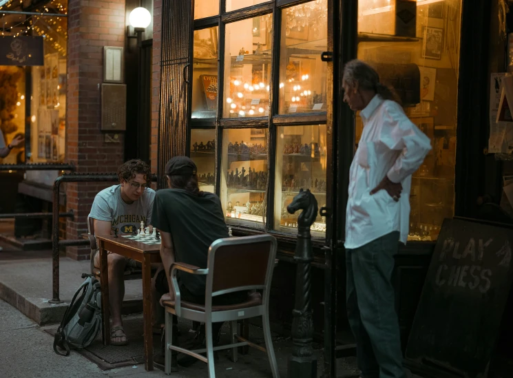 some people sitting down at a table with a light on