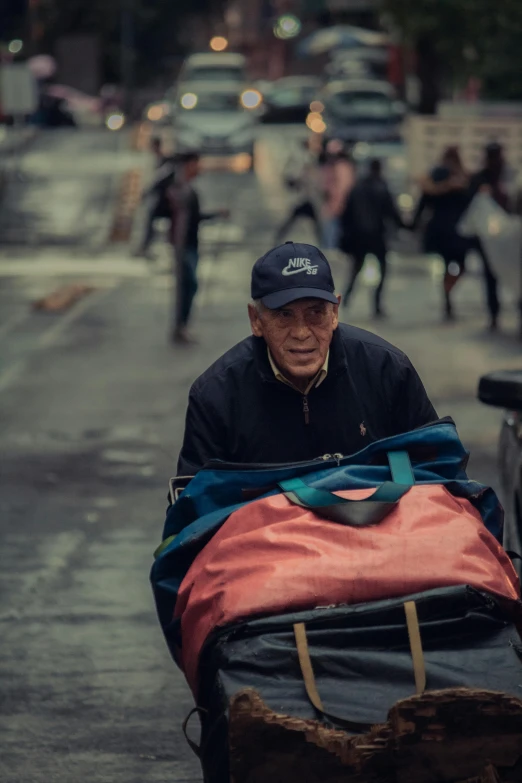 an old man carrying a blanket in a cart