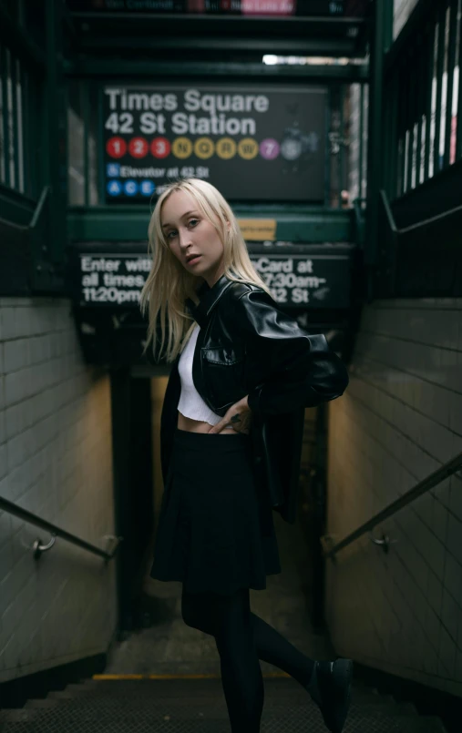 a woman with blonde hair wearing black skirt and jacket