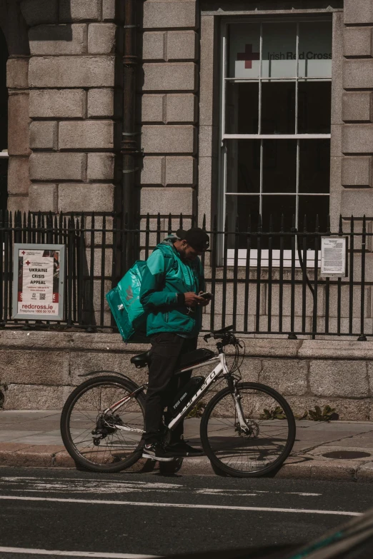 a man walking across the street by his bike