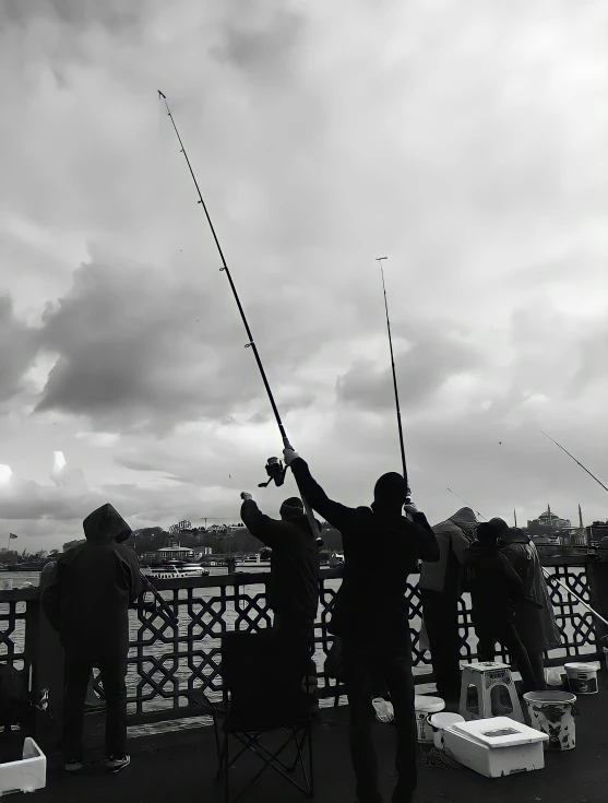 several people stand on a bridge as they fish