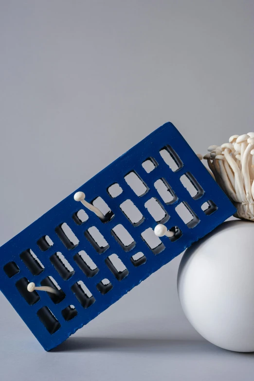 two plastic objects with white and blue ones on a grey surface