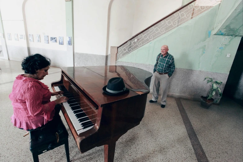 an old man and a young woman at a piano