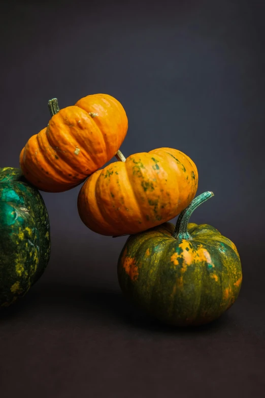 three pumpkins and one is green and yellow