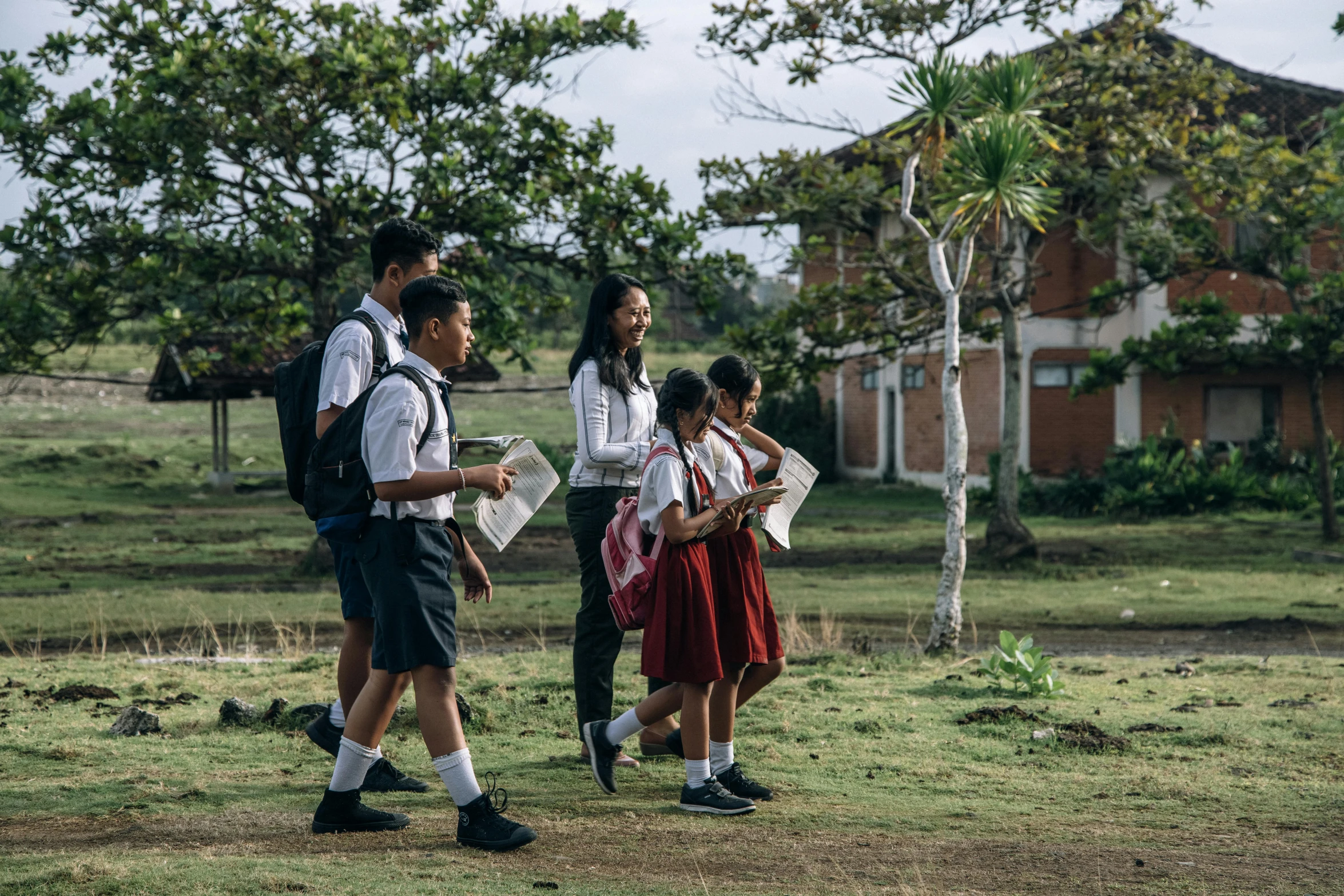 a group of children are walking and holding soing