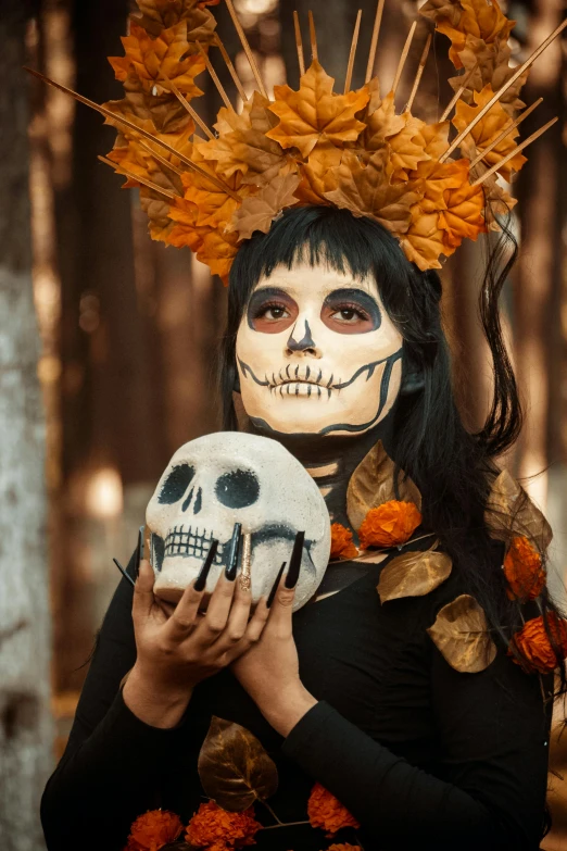 the woman with the skull makeup is holding a human skull