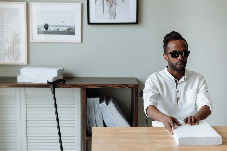 man sitting at desk in glasses reading a book