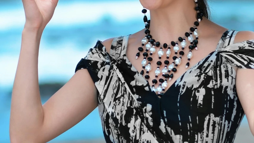 a lady wearing an elegant dress with a necklace, pearls and pearles