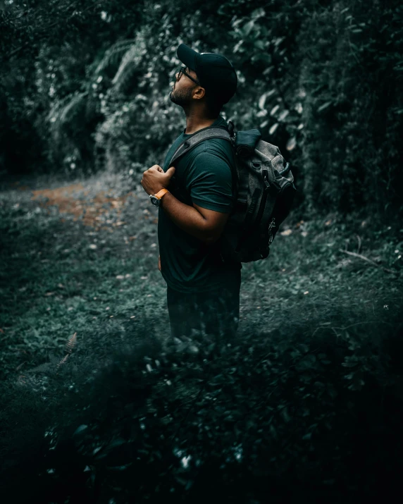 man standing in woods holding onto an object