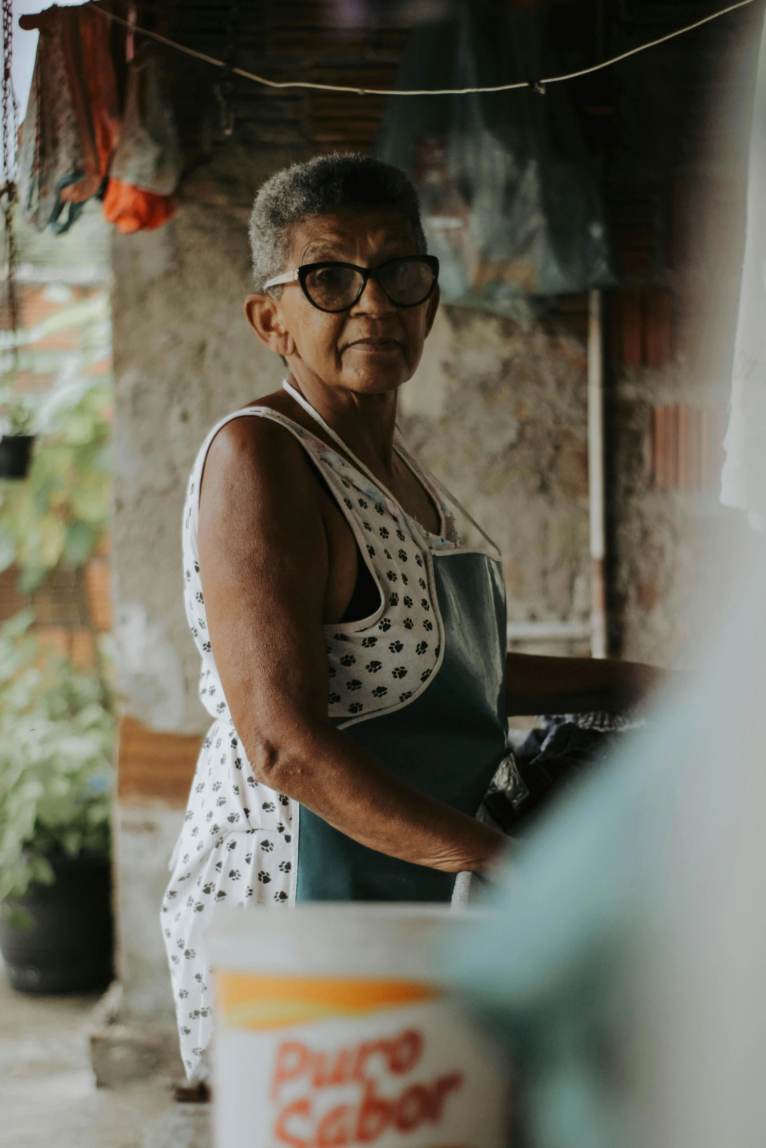 an old woman working in her kitchen cooking food