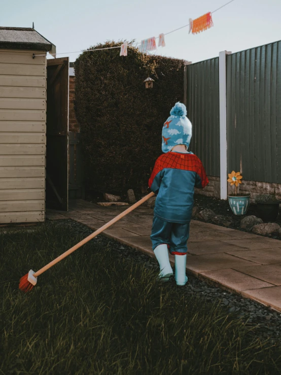 the young child has thrown a broom into the yard