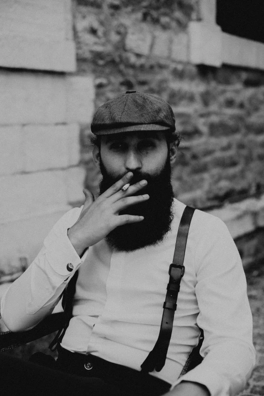 a man with a beard and hat sitting down