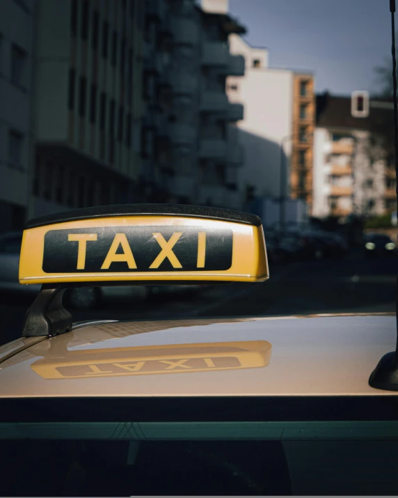 an yellow and black taxi sign on top of a car