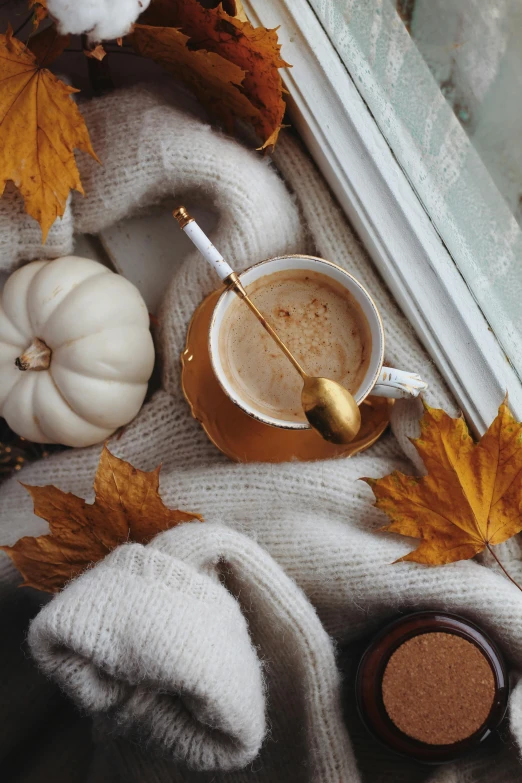 a cup of coffee is placed on a window ledge and next to two small mugs