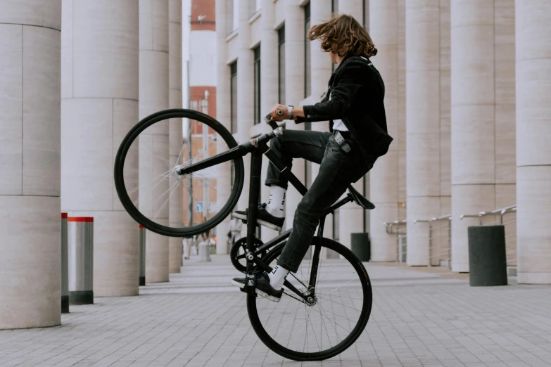 a man is jumping over a bike on a sidewalk