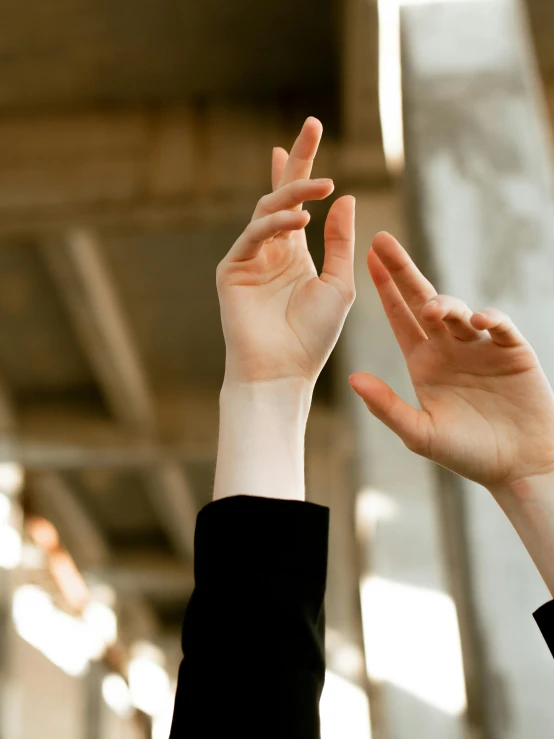 two people hold their hands up high