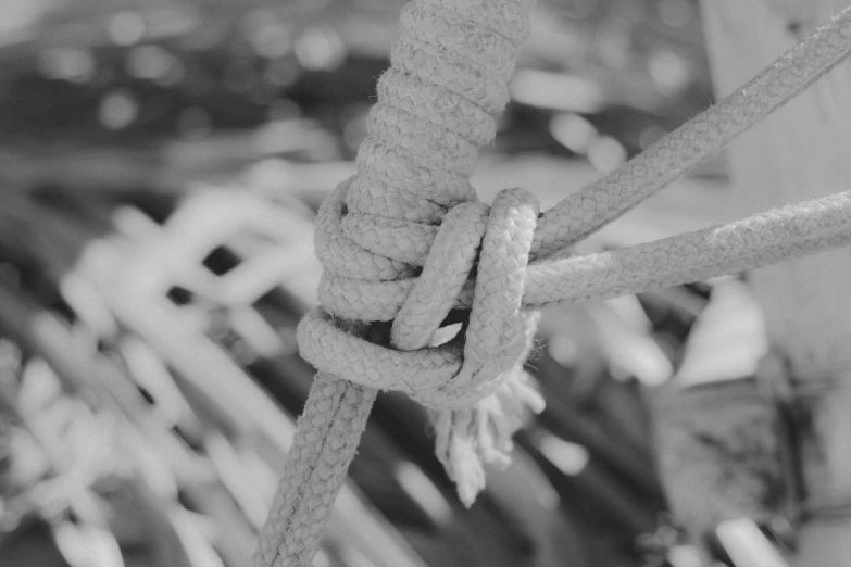 a rope tied to an old boat in black and white