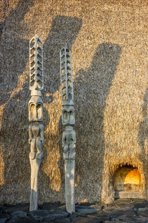 two decorative, carved candles in a stone display