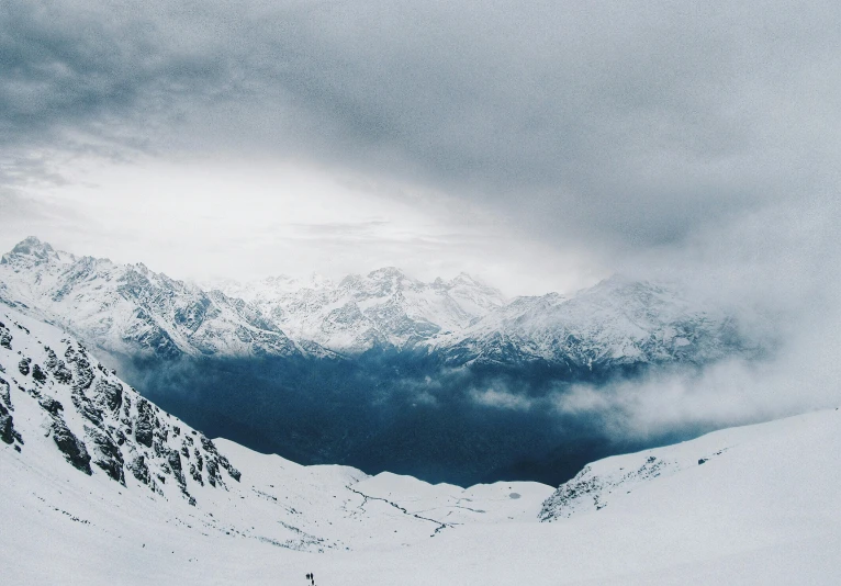 a view of a cloudy mountain range in the winter