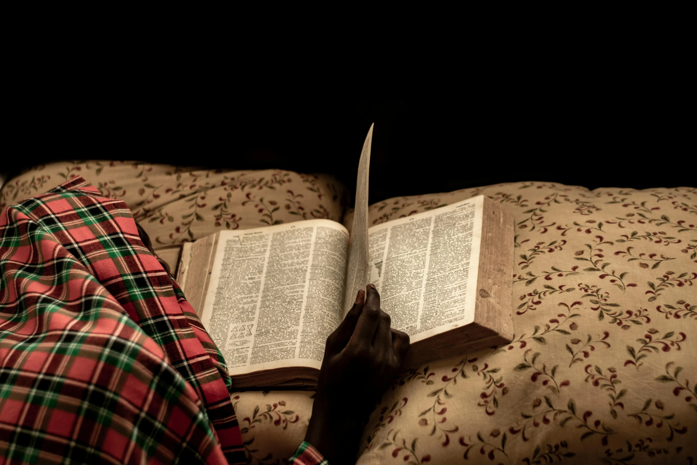 a person is reading a book and holding it over their head