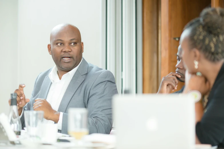 man in a suit talking with other people