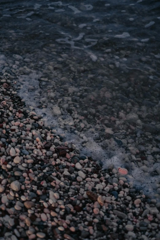 a beach is covered with pebbles and water