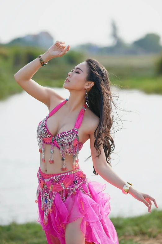 a girl in a pink dress by a pond