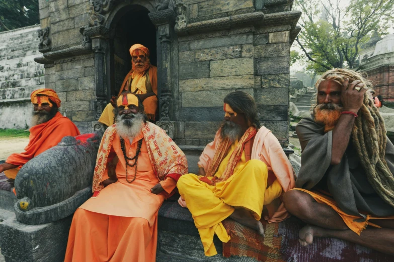 group of people with turbans sitting outside building