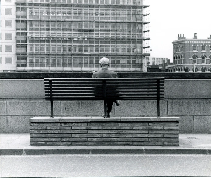 an old woman sits alone on a bench