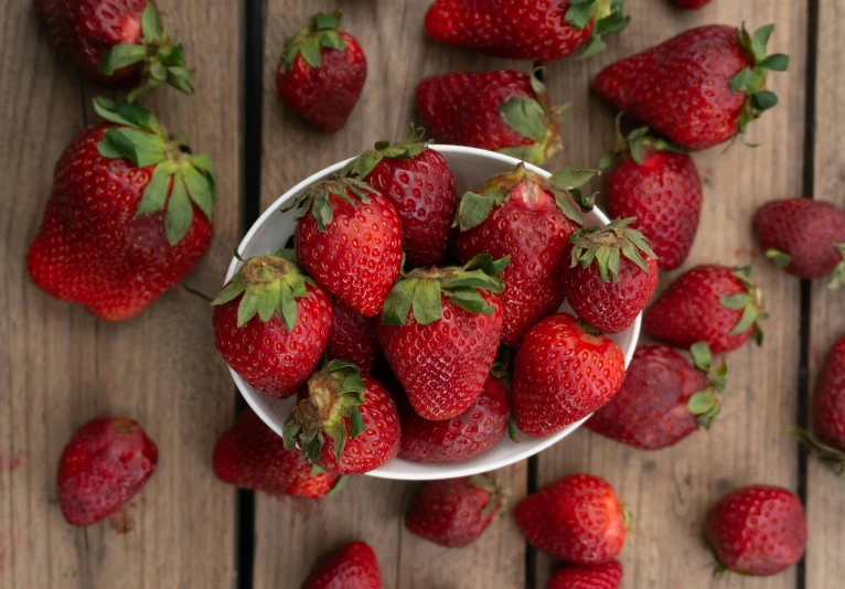 a bowl full of strawberries sitting on a table