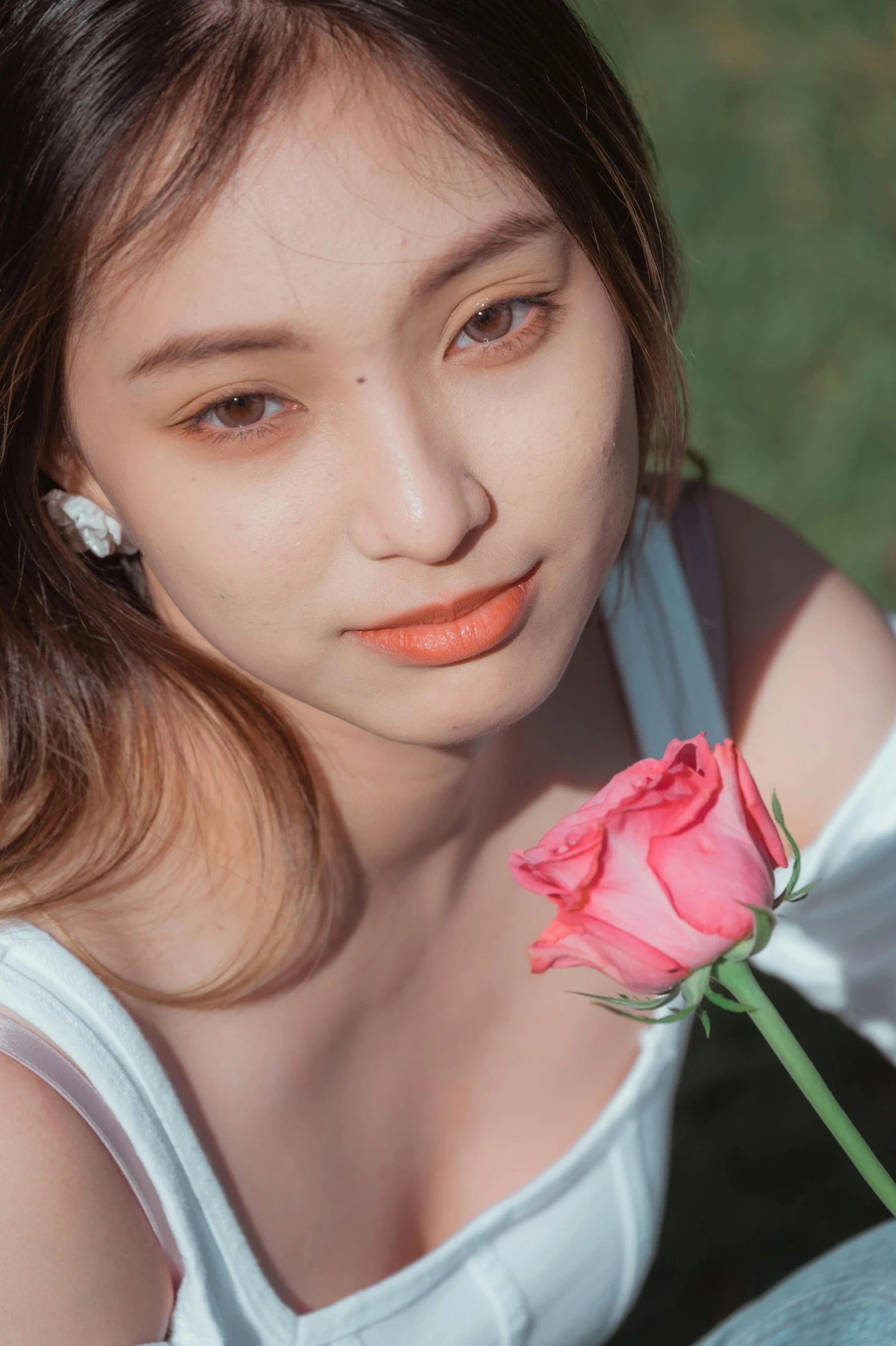 woman holding a single rose while posing for a picture