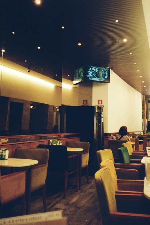 a dining area with wooden tables and yellow chairs