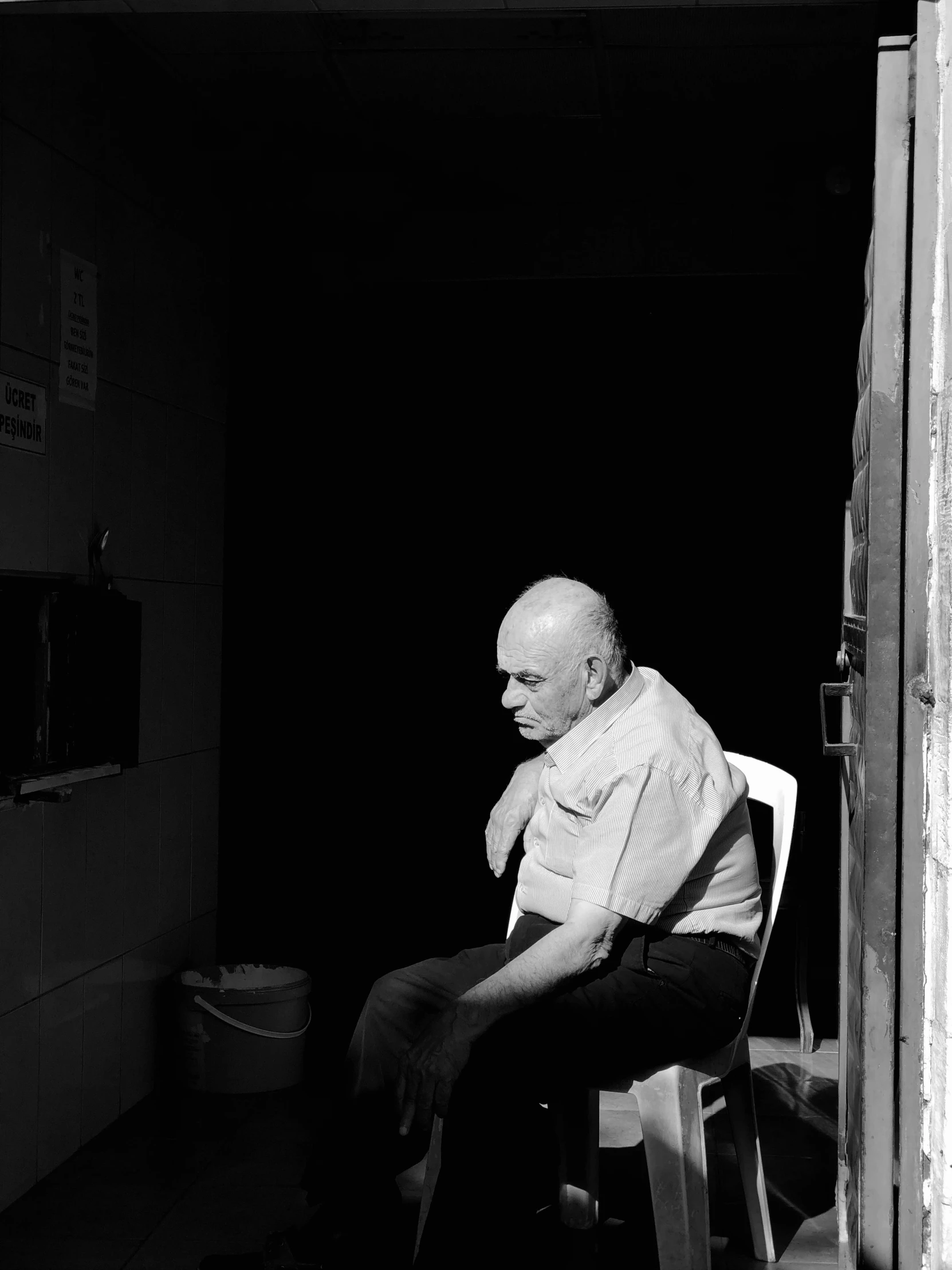 a black and white po of an old man sitting in a chair