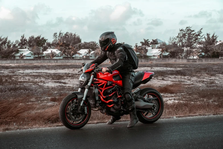 a person on a motor bike standing on the side of the road