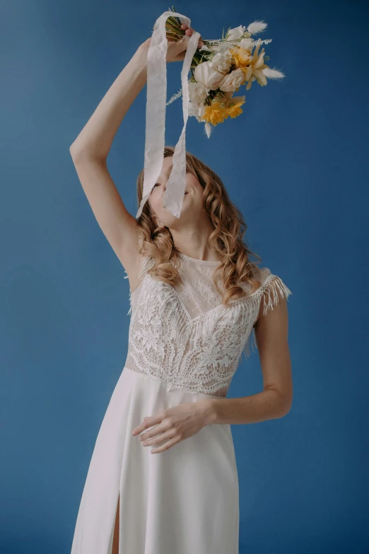 a beautiful woman wearing a wedding dress is holding a bouquet