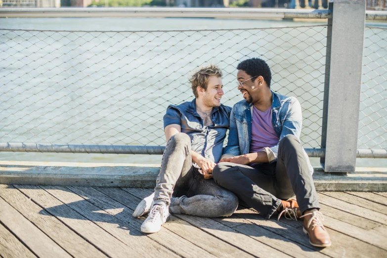 two men sitting down smiling and looking at each other