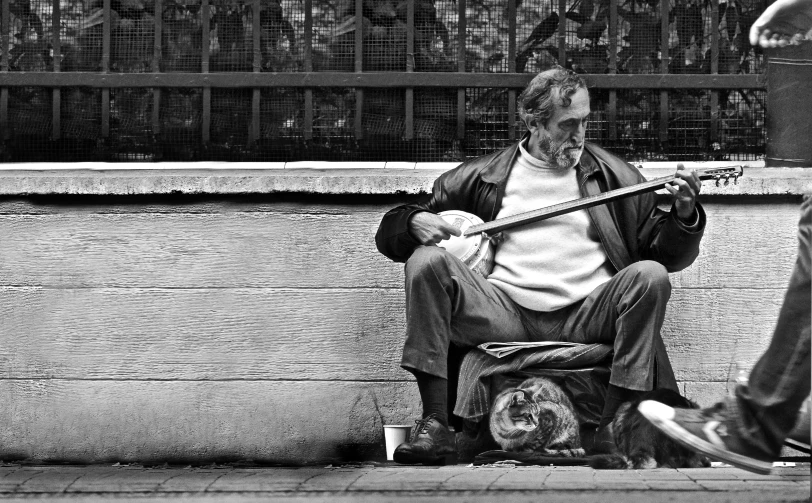 a man sits on a bench next to another person